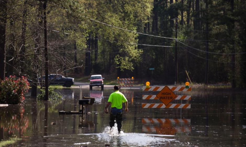 A man walks through floodwaters from Caddo Lake in Mooringsport, La., Sunday, March 13, 2016. President Barack Obama has signed an order declaring Louisiana's widespread flooding from heavy rains a major disaster. Photo: Lee Celano/The Shreveport Times via AP