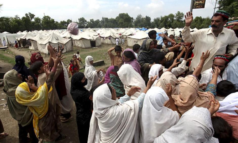 Flood-affected crowds get relief food at a camp in Nowshera, northwest Pakistan, on Monday. The number of people suffering from the disaster now exceeds 13 million. Photo: Sajjad, AP