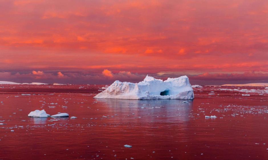 A startling sunset reddens the Lemaire Channel, off the west coast of the Antarctic Peninsula. The continent’s coastal ice is crumbling as the sea and air around it warm. Photo: Camille Seaman
