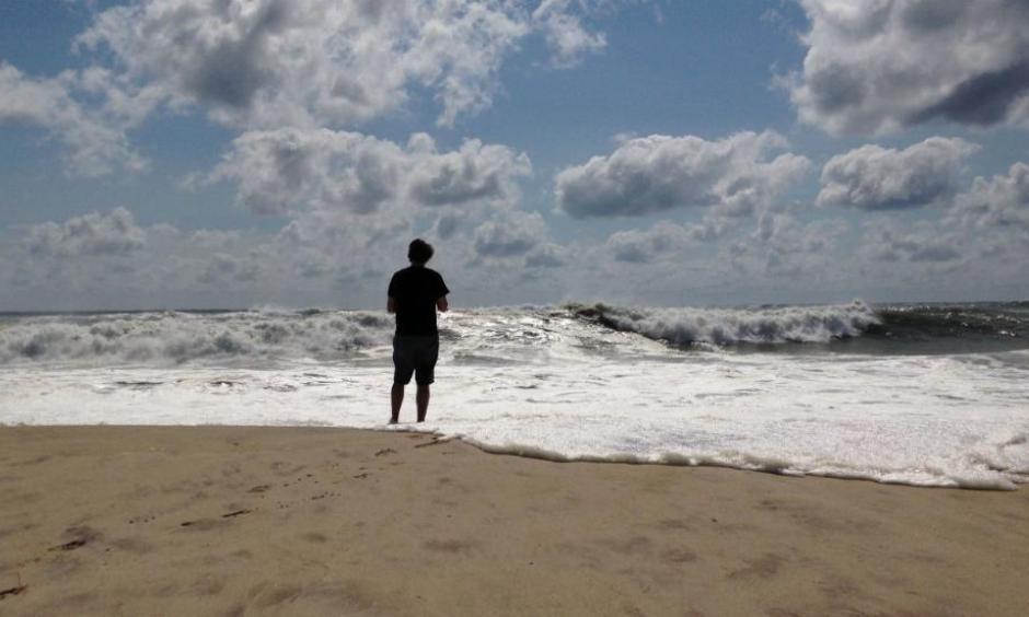 A beachgoer stands at the edge of the water, Sunday, Sept. 4, 2016, in Bridgehampton, New York, on the southeastern shore of Long Island, where the effects of storm system Hermine could be seen in the rough surf and a ban on swimming. Photo: Jennifer Peltz, AP