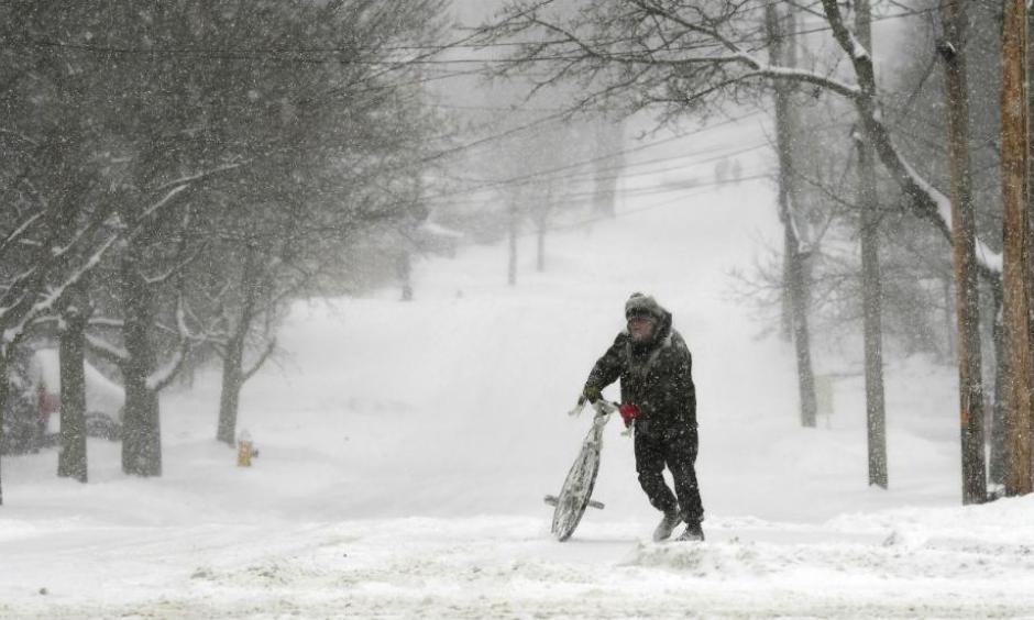 Jake Robinson walks his bike during a winter storm in Auburn, New York, Tuesday, March 14, 2017. A blustery, late-season storm clobbered the Northeast with sleet and heavy snow Tuesday, crippling much of the Washington-to-Boston corridor after a stretch of unusually mild winter weather that had people thinking spring was already here. Photo: Kevin Rivoli, The Citizen via AP