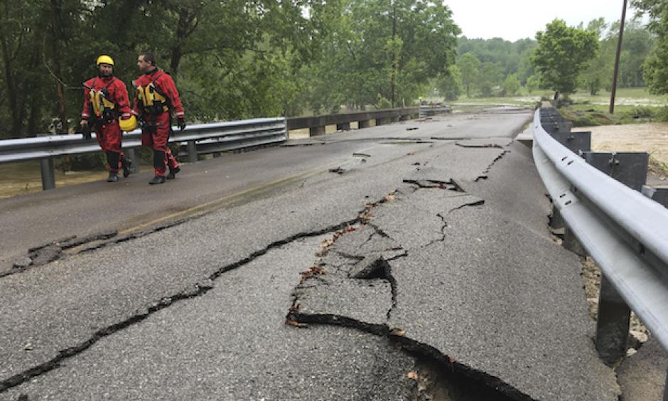 Rescuer workers walk down a road damaged by flash flooding, Friday, May 19, 2017, in Sumner County, Tenn. Overnight storms brought several inches of rain, causing several creeks to rise. Photo: Lacy Atkins/The Tennessean via AP
