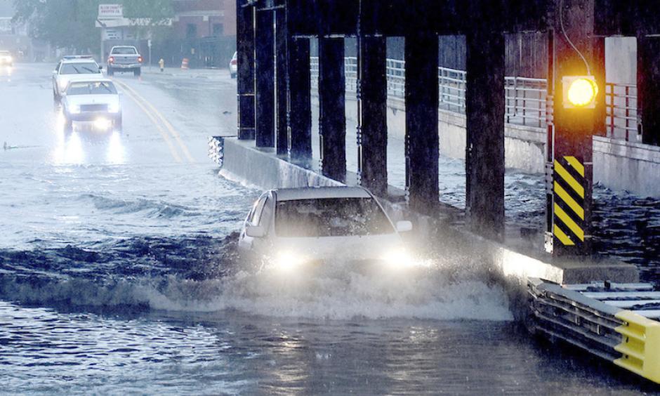A car is partially submerged as it travels beneath a railroad underpass in Fort Wayne, Ind., on Thursday, May 25, 2017, following heavy rains that sparked flash flooding in the northeastern Indiana city. Photo: Samuel Hoffman, The Journal-Gazette via AP