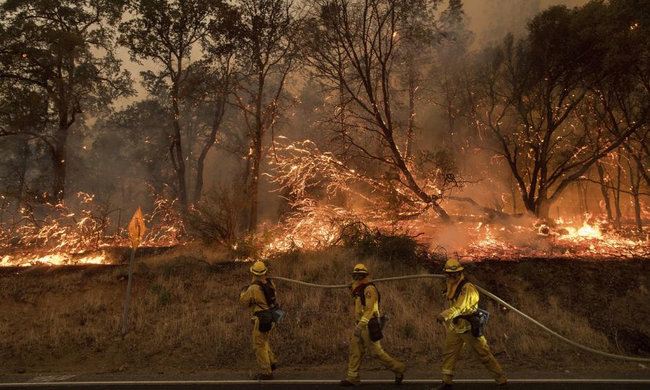 Firefighters try to keep a wildfire from jumping a street near Oroville, Calif., on Saturday. Evening winds drove the fire through several neighborhoods, leveling homes in its path. Photo: Noah Berger, AP