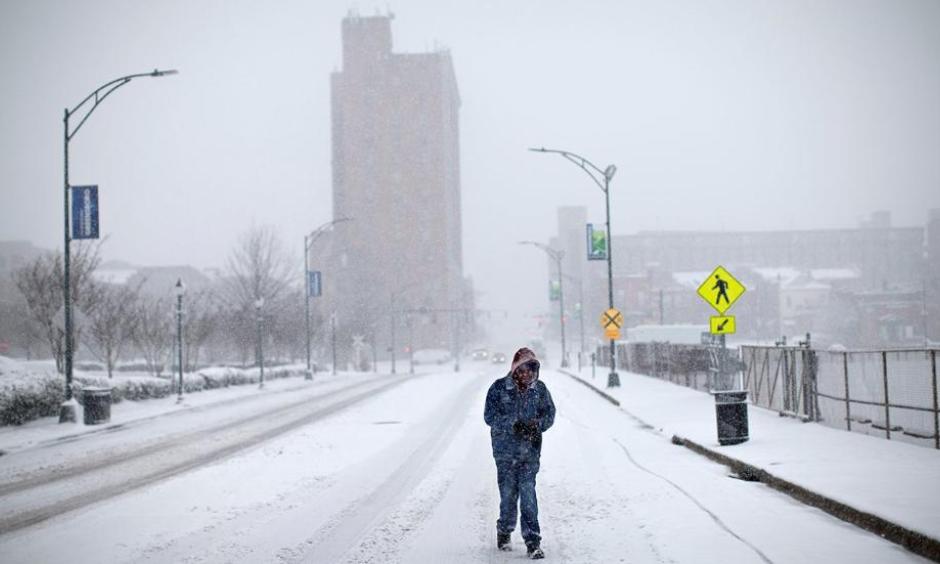 A pedestrian walks down the middle of Washington Street, Wednesday, Jan. 17, 2018, in Greensboro, N.C. The National Weather Service has issued a winter storm warning for Greensboro with a snow accumulation between 4-7 inches expected. Photo: Andrew Krech, News & Record via AP