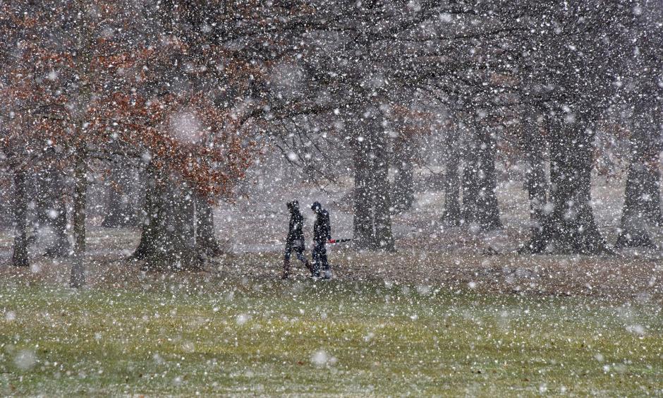 People cross Flagstaff Hill as snow falls in Schenley Park in the Oakland section of Pittsburgh on Tuesday, March 20, 2018. Photo: Darrell Sapp/Pittsburgh Post-Gazette via AP