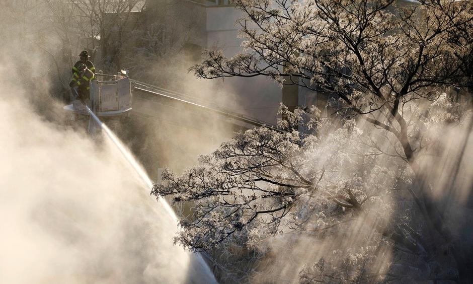 Ice forms on tree branches as New York firefighters battle a blaze in a commercial building in the Bedford Stuyvesant neighborhood of Brooklyn, Thursday, Jan. 31, 2019 in New York. Firefighters around New York state have been grappling with brutal cold during big blazes. Photo: Mark Lennihan, AP