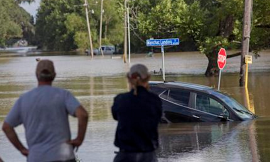In this Aug. 16, 2016 file photo, residents survey the flood water on Old Jefferson Highway at Bayou Manchac in Prairieville, La. The flooding killed at least 13 people, damaged 150,000 homes and cost at least $8.7 billion. Photo: Max Becherer, AP