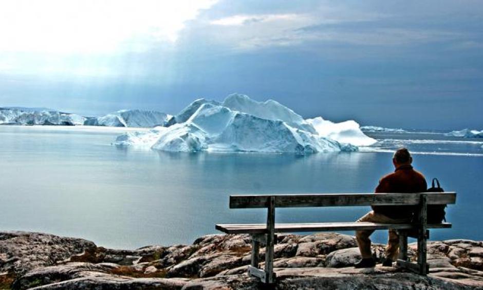 An old man looks out on a Greenland glacier. (Flickr/Goran Ingman)