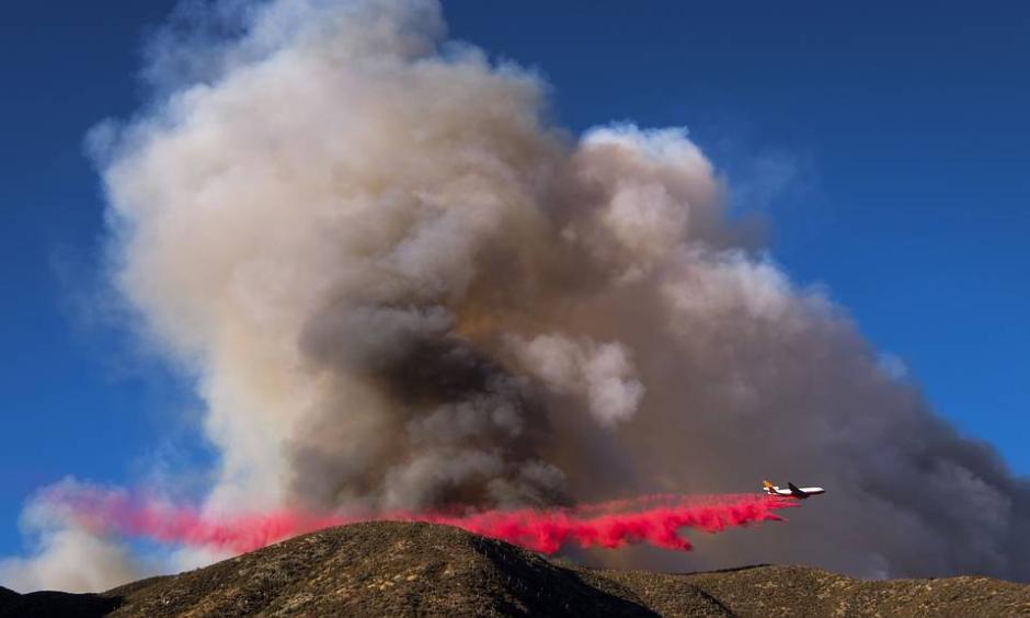 An air tanker dropped fire retardant on what has been named the Blue Cut wildfire in Lytle Creek, Calif., on Tuesday. About 700 personnel are involved in containment and evacuation efforts, officials say. Photo: Ringo Chiu, Agence France-Presse, Getty Images