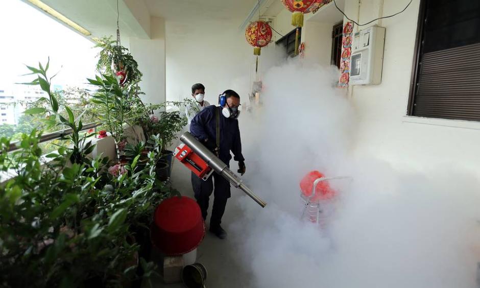 Workers fogged a housing estate in Singapore to kill mosquitos on Sunday. Photo: Agence France-Presse / Getty Images