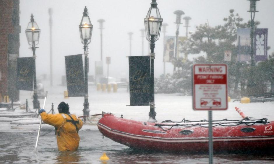 A Boston firefighter wades through flood waters from Boston Harbor on Long Wharf on Thursday, Jan. 4, 2018, after Winter Storm Grayson’s storm surge brought the highest coastal water levels ever recorded in Boston. Photo: Michael Dwyer, AP