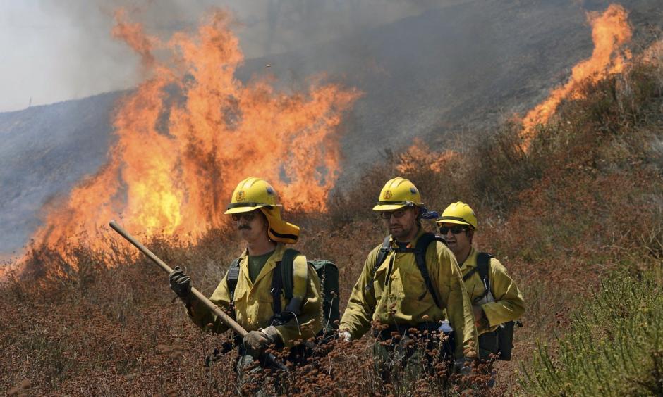 Firefighters battle the Bluecut Fire along Swarthout Canyon Road in the Cajon Pass, north of San Bernardino, Calif., Tuesday August 16, 2016. The blaze 60 miles east of Los Angeles has burned what appear to be several ranch outbuildings and forced evacuations in and around Lytle Creek. Photo: Will Lester / The Sun via Associated Press