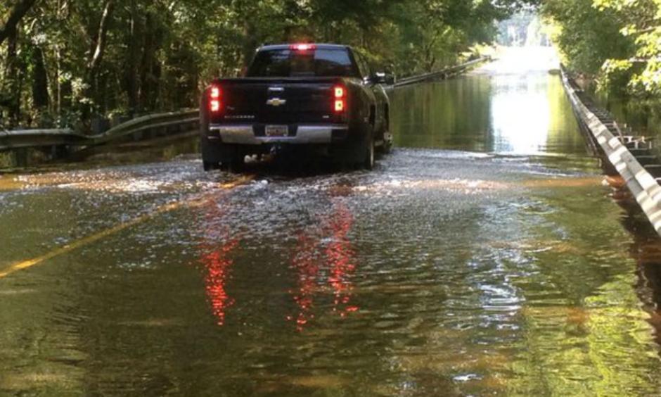A truck goes through a flooded road. Photo: Venton Blantin