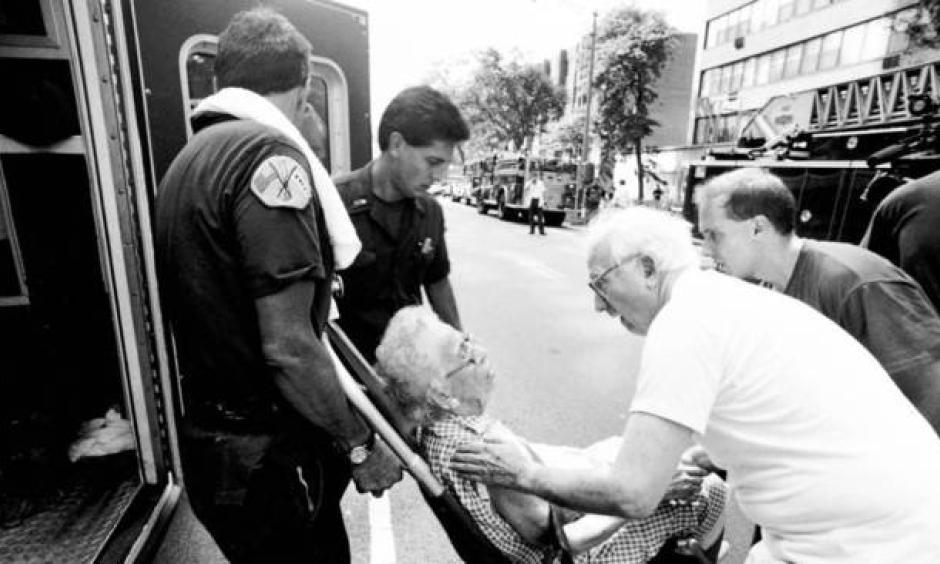 A 101-year-old woman is assisted after being overcome by heat later in the summer when an electrical fire knocked out the power in her apartment building. Photo: Chicago Tribune