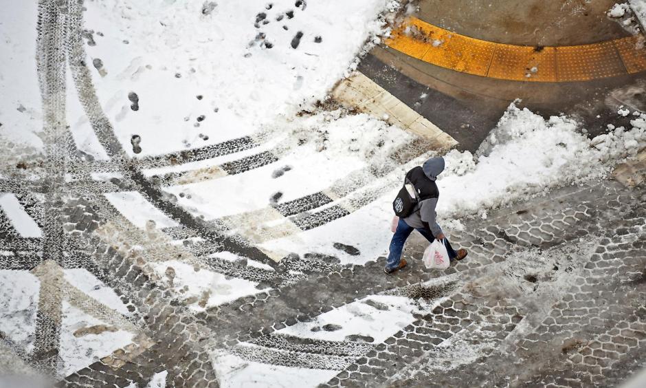 A pedestrian walks across the street in downtown Scranton, Pennsylvania January 20 after a major winter storm brought some of the coldest temperatures of the season and covered a large swath of the country in snow. It wreaked havoc on air travel and caused slick road conditions throughout New England. Photo: Butch Comegys, Times-Tribune via AP