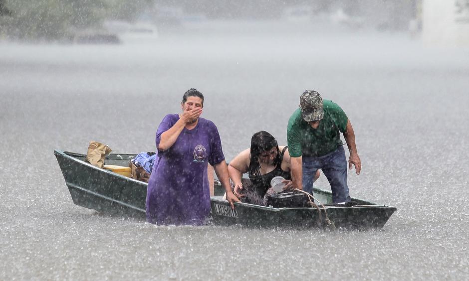 Dee Vazquez, from left, helps Georgette Centelo and her grandfather Lawrence Roberts after they tried to recover their belongings from a family mobile home in Central, north of Baton Rouge, La., Monday, Aug. 15, 2016. Photo: David Grunfeld / The Times-Picayune via AP