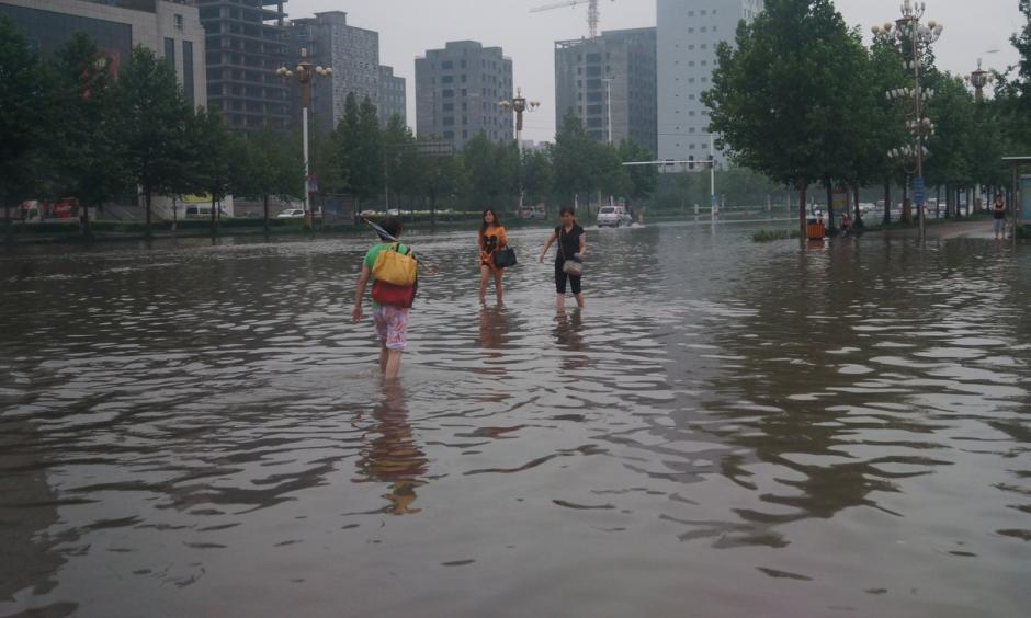 Chinese residents wading through floodwaters. Currently, global average annual flood losses are estimated at $104 billion. Photo: Language Teaching Flickr, CC BY 2.0