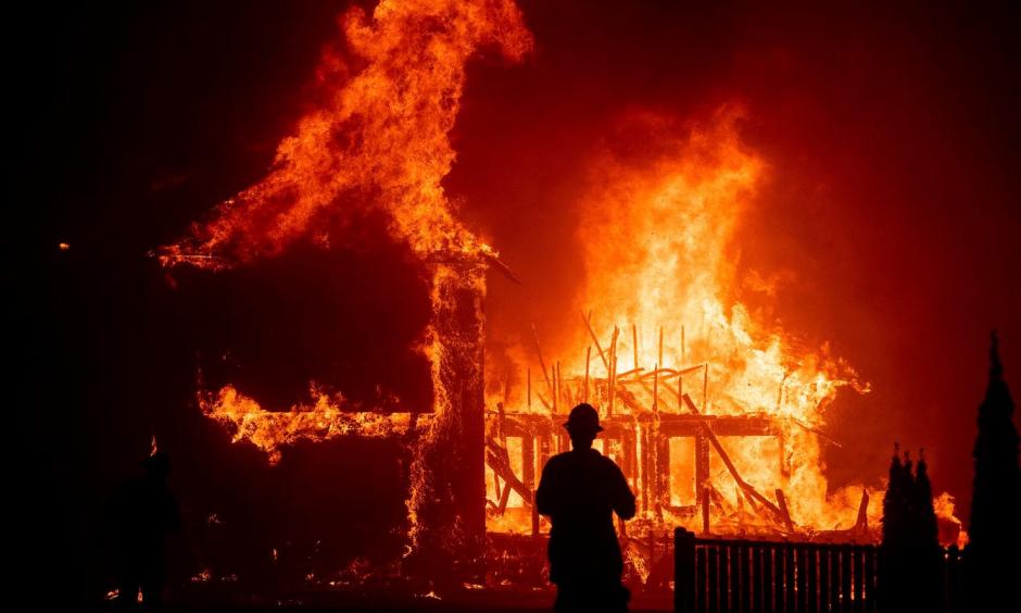 A home burns as the Camp Fire rages through Paradise, Calif., in November 2018. Credit: Noah Berger, Associated Press