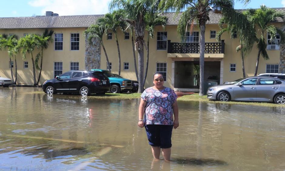 Karina Castillo, an activist for the group Mom's Clean Air Force, standing in tidal flooding in Shorecrest, Miami. Photo: Dayna Reggero for Clean Air Moms Action