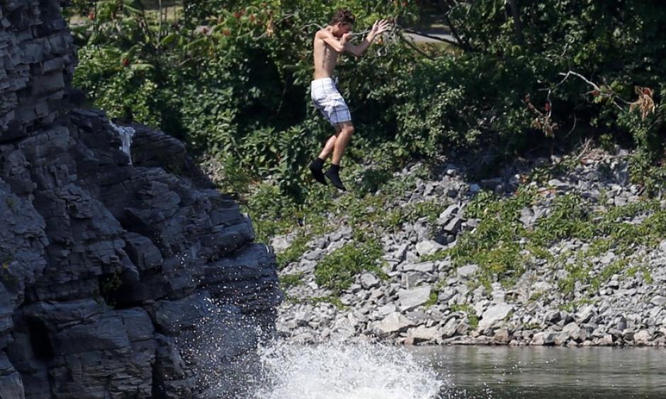 A boy jumps into the Ottawa River in Quebec on August 10, 2016. Photo: Chris Wattie / Reuters