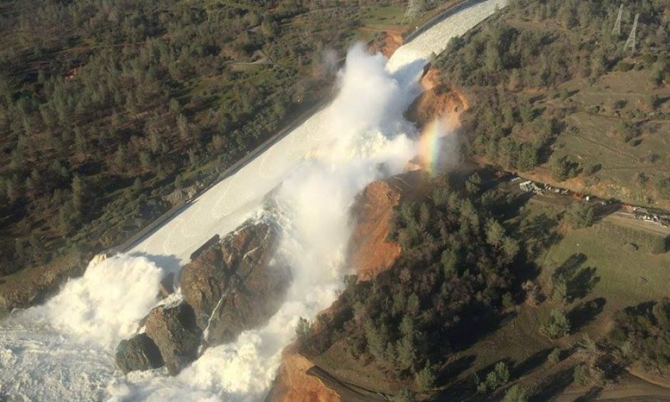 Water pours over the damaged main spillway at the Oroville Dam and over a hillside. Photo: California Department of Water Resources