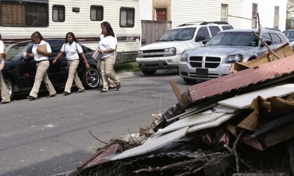 Students walk next to a pile of debris. Students walk past a debris pile from a house damaged during Hurricane Katrina. Photo: Lee Celano, Reuters