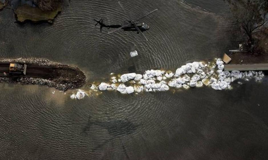 A helicopter tries to repair a breached New Orleans levee that was damaged by Katrina. Photo: Gabooza