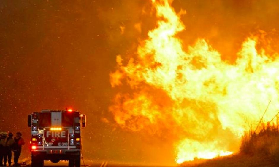 Firefighters huddle for shelter while battling a fire in Southern California this week. Photo: Reuters