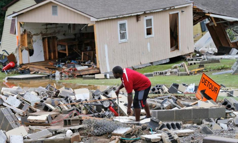 A White Sulphur Springs resident sorts through debris as the cleanup begins from severe flooding in White Sulphur Springs, West Virginia. Photo: Steve Helber, AP