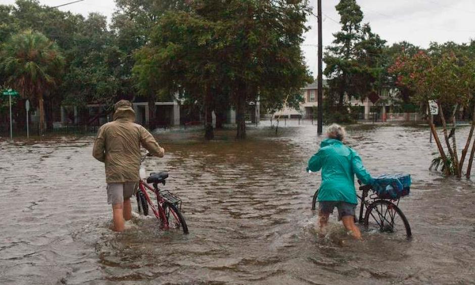 A couple walks their bikes through a flooded street in Mandeville, Louisiana, north of New Orleans, on Sunday, July 14, 2019, after Tropical Storm Barry came ashore. Credit: Seth Herald, AFP, Getty Images