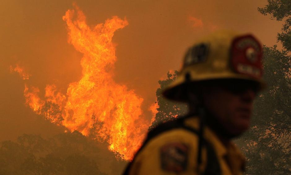 A firefighter monitors flames from the Rocky Fire as it approaches a home late last month. The wildfire has consumed thousands of acres in just over a week. Image: Justin Sullivan/Getty Images