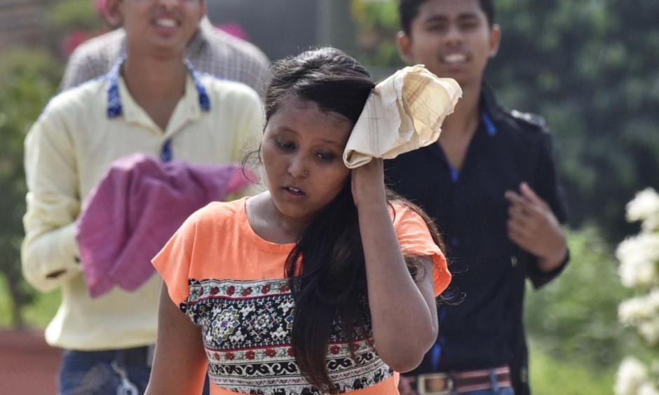 Visitors try to cover themselves to avoid heat wave during a hot weather on May 22, 2016 in New Delhi, India. Photo: Sanjeev Verma, Hindustan Times/ Getty Images