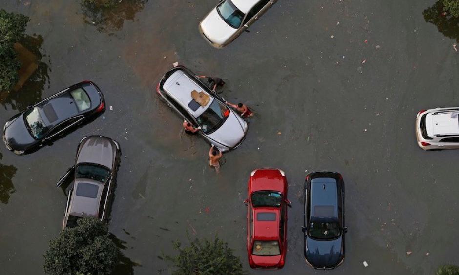 Vehicles are submerged in floodwaters on July 9, 2016 in Wuhan, Hubei Province of China. Many parts of the Wuhan area were submerged in floodwaters during July as torrential rains affected the Yangtze River valley. A new study finds that climate change increased the risk of the rains that led to the flooding by 17 – 59%. Photo: VCG/VCG via Getty Images.