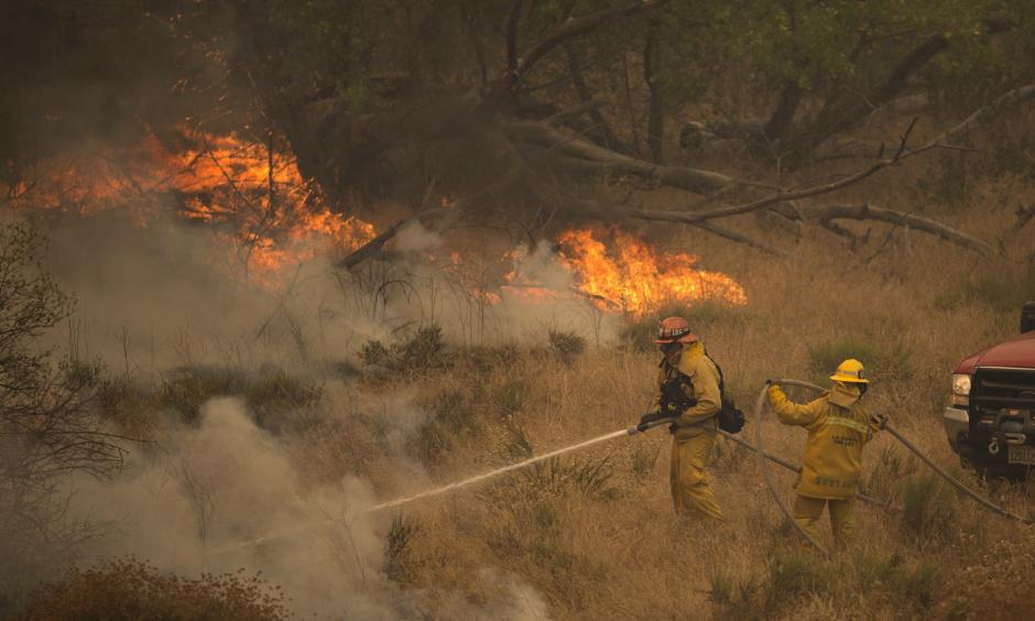 Firefighters retreat ahead of flames in Placerita Canyon north of Los Angeles on Sunday. The Sand Fire there has burned an estimated 33,000 acres of dry vegetation, and thousands of people have been evacuated from their homes. Photo: David McNew/Getty Images