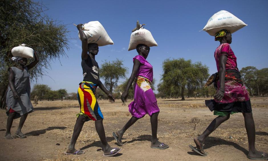 Women carry food in gunny bags after visiting an aid distribution center in South Sudan on March 10. Photo: Albert Gonzalez Farran, AFP, Getty Images