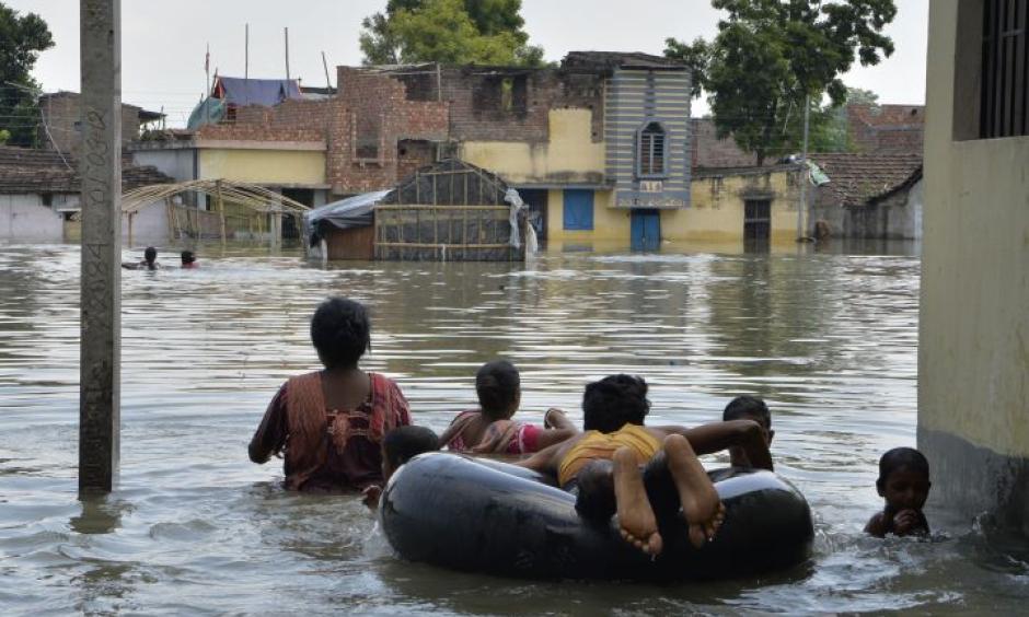 Indian residents wade through flood waters in Malda in the Indian state of West Bengal. Photo: AFP