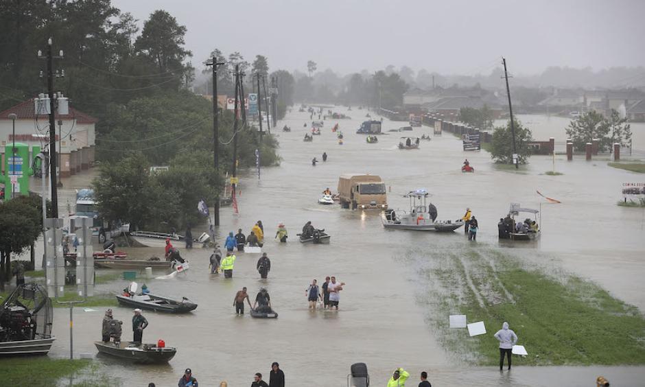 People walk down a flooded street as they evacuate their homes after the area was inundated with flooding from Hurricane Harvey on August 28, 2017 in Houston, Texas. Photo: Joe Raedle, Getty Images