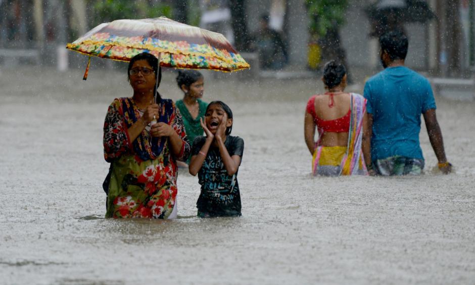 People wade through a flooded street in Mumbai, India, on August 29th, 2017. Photo: Punit Paranjpe, AFP/Getty Images