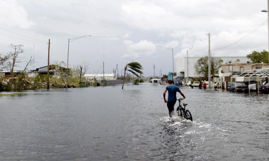 A man pushes his bicycle through a flooded street in Cataño, Puerto Rico, on Friday. Hurricane Maria drenched many spots on the island with about 20 inches of rain. Photo: Ricardo Arduengo/AFP/Getty Images