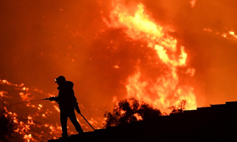 California resident waters a roof as the Thomas Fire approaches the town of La Conchita early Thursday morning. Photo: Wally Skalij, Los Angeles Times/Getty