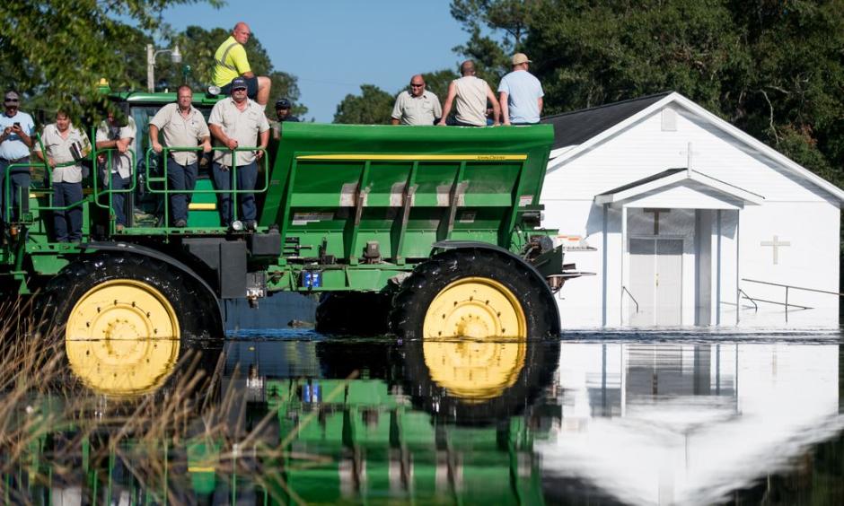 Workers use farm machinery to navigate floodwaters from the Waccamaw River caused by Hurricane Florence in Bucksport, South Carolina. Sea-level rise exacerbated flooding from the storm. Photo: Sean Rayford, Getty Images