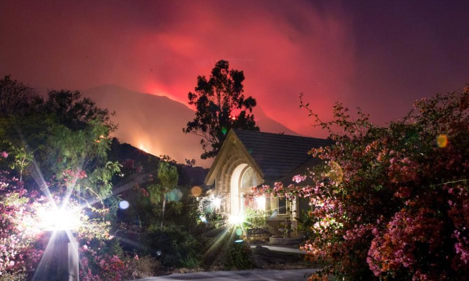 The Thomas Fire burns behind houses in Ojai, California, December 7, 2017. Photo: Kyle Grillot, AFP/Getty Images