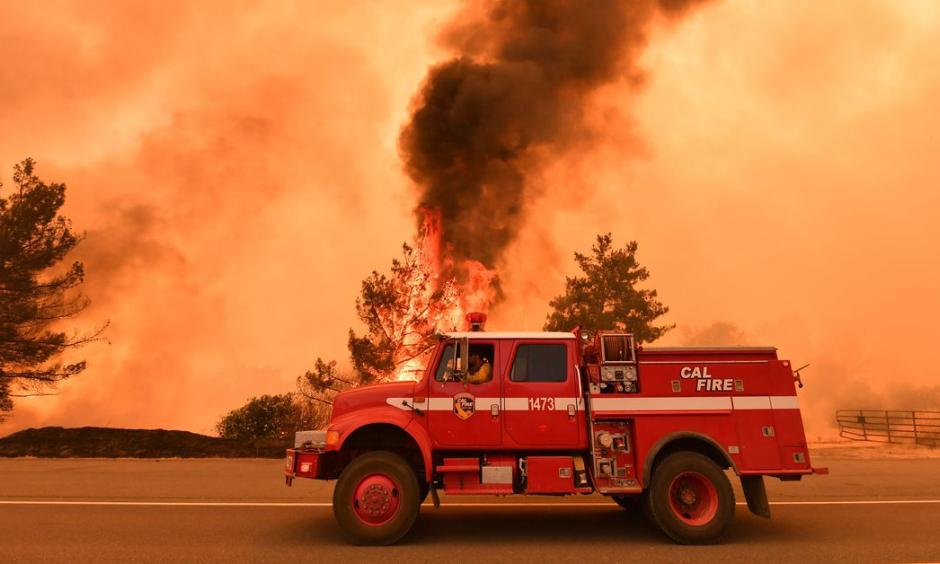 Firefighters work to control a fire as flames from the County Fire jump across Highway 20 near Clearlake Oaks, California, on July 1, 2018. Photo: Josh Edelson, AFP/Getty Images