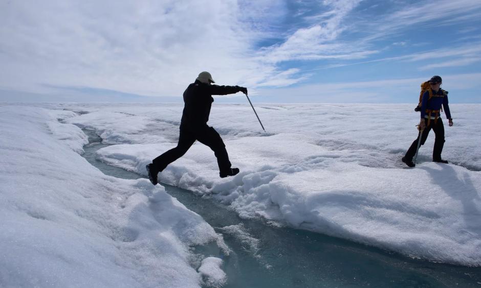 A scientist leaps over water during a trip to the Greenland ice sheet, which saw melting over more than 50% of its surface last year. Photo: Joe Raedle/Getty Images