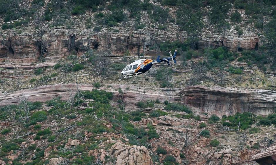 A helicopter flies above the rugged terrain along the banks of the East Verde River during a search and rescue operation for victims of a flash flood, July 16, 2017, in Payson, Ariz. Photo: ABC News