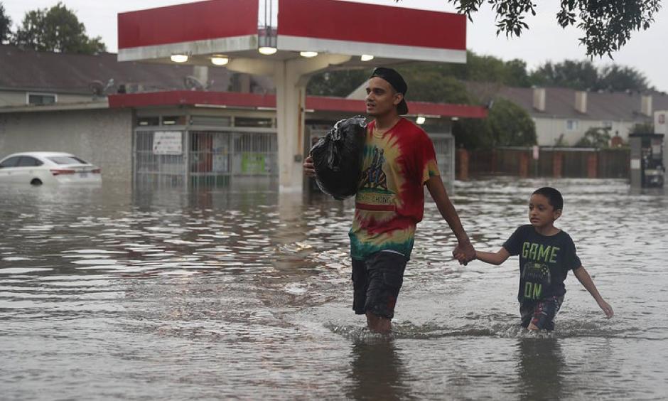 People walk down a flooded Houston street as they evacuate their homes Sunday after Hurricane Harvey hit. Joe Raedle, Getty Images
