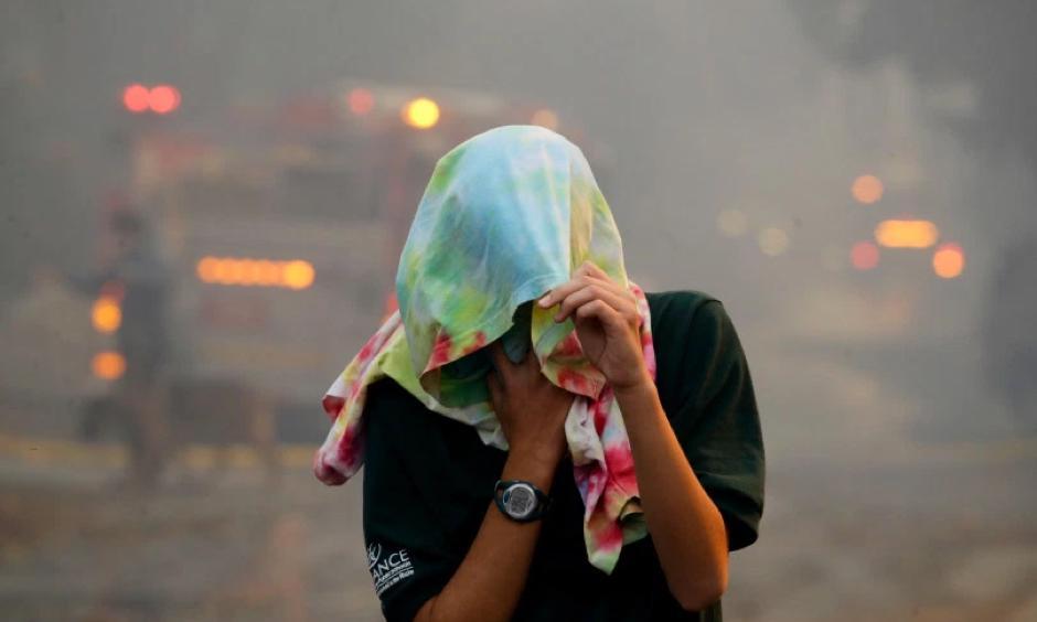A resident flees a wildfire in the Lake View Terrace area of Los Angeles Tuesday, Dec. 5, 2017. Ferocious winds in Southern California have whipped up explosive wildfires, burning a psychiatric hospital and scores of other structures. Photo: Chris Carlson, Associated Press