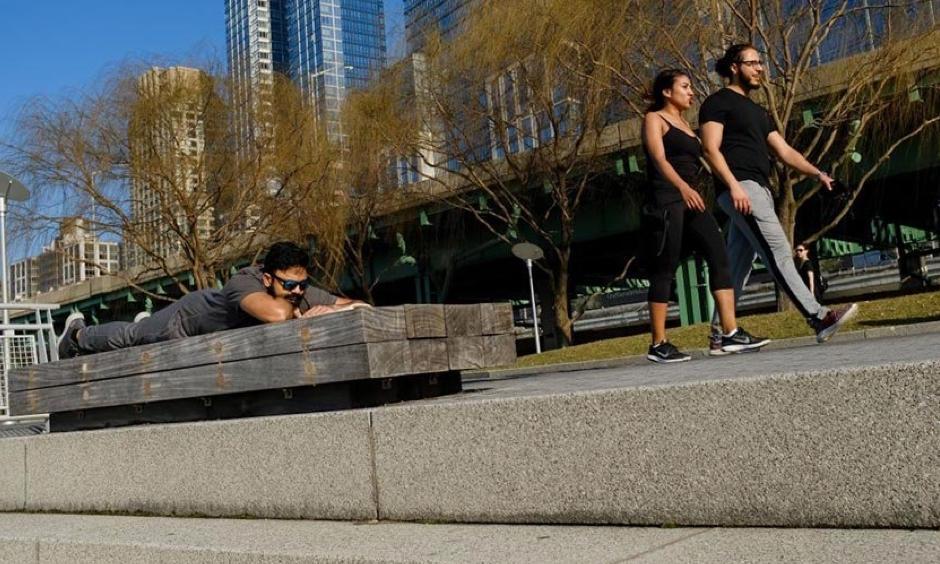 A man reads a book as people walk along the Hudson River Greenway on an unseasonably warm afternoon, February 21, 2018 in New York City. New York City recorded their warmest February day on record: 78°. Photo: Drew Angerer, Getty Images