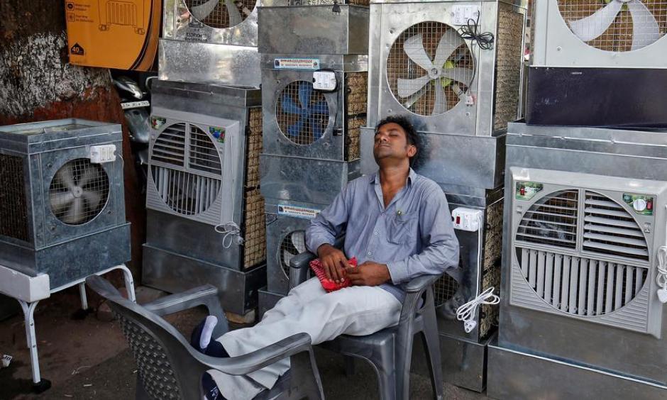 A man selling air coolers rests at a market on a hot summer day in Odisha. Photo: Reuters